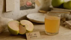Jus de pommes bienfaits : pomme coupée et verre de jus frais sur table en bois